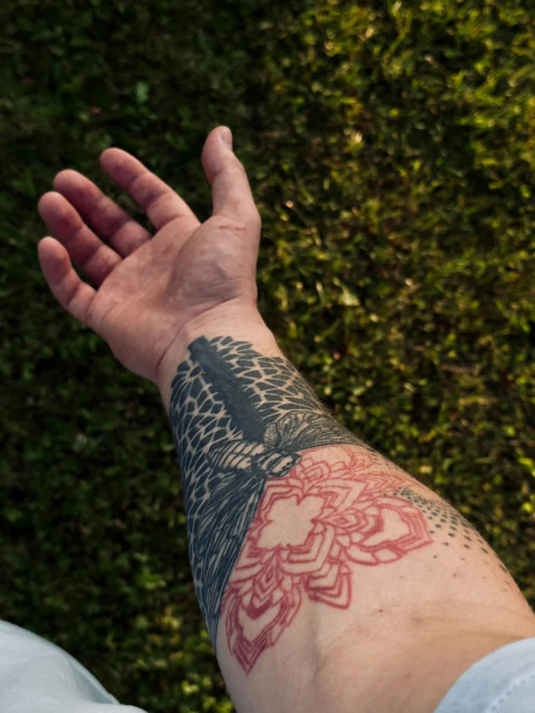 Illustrative floral and character work on an arm