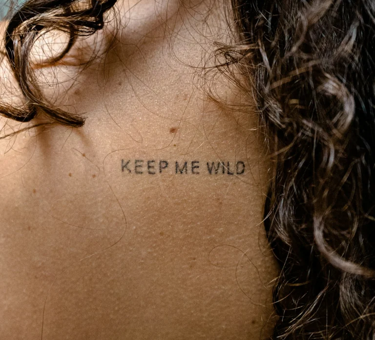 Script reading “keep me wild” across the upper back