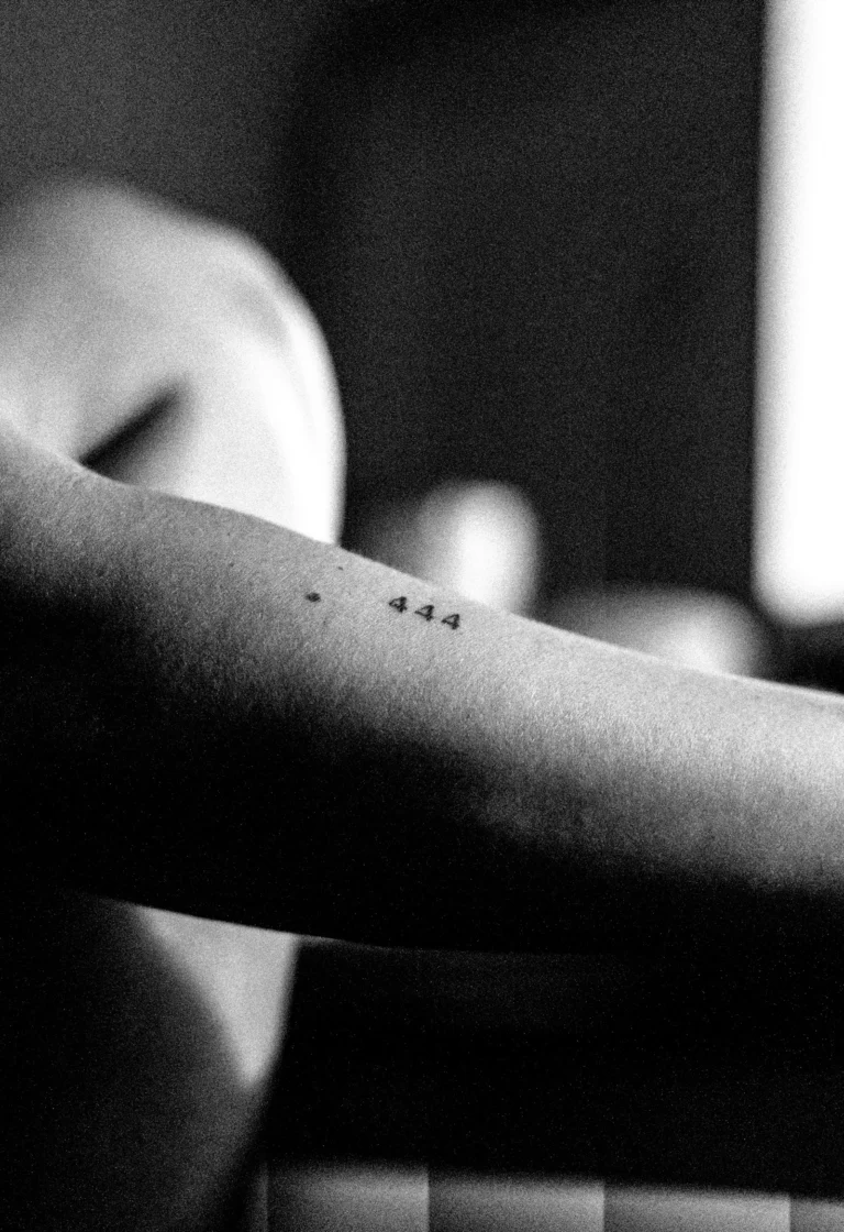 A tiny 444 tattoo on the forearm