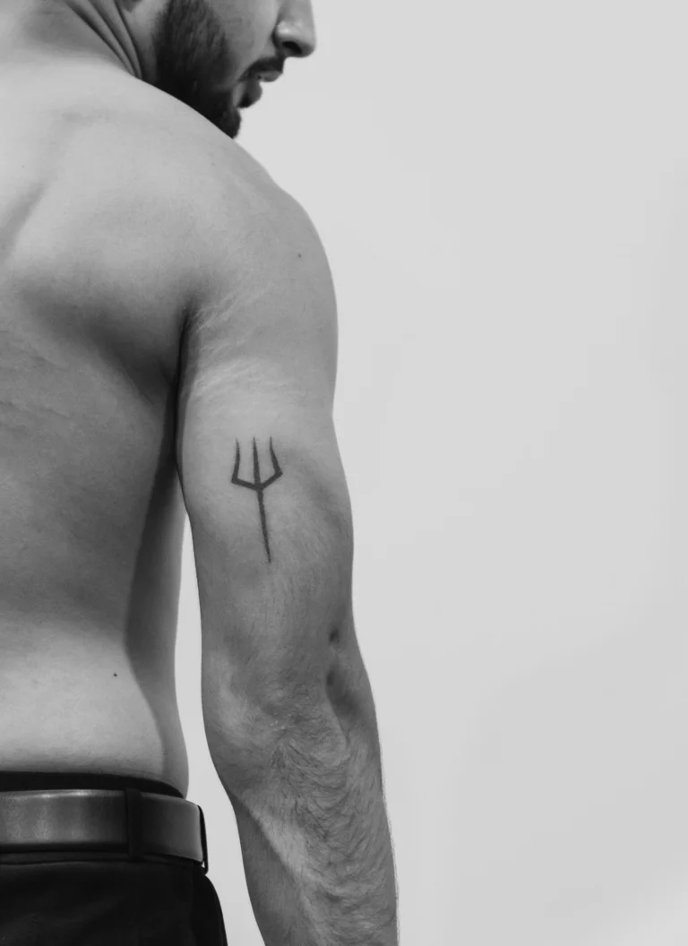 A small trident on the upper arm