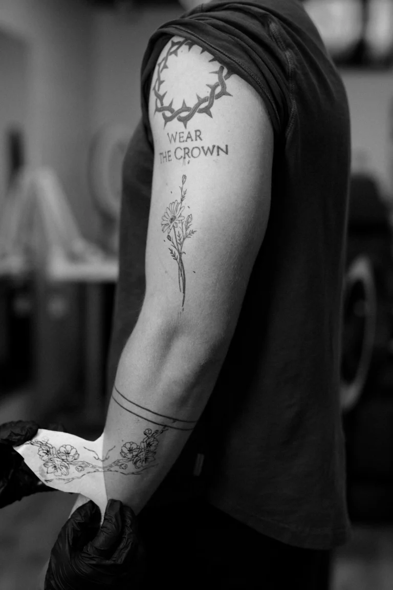 Fine-line botanical tattoo running down an arm