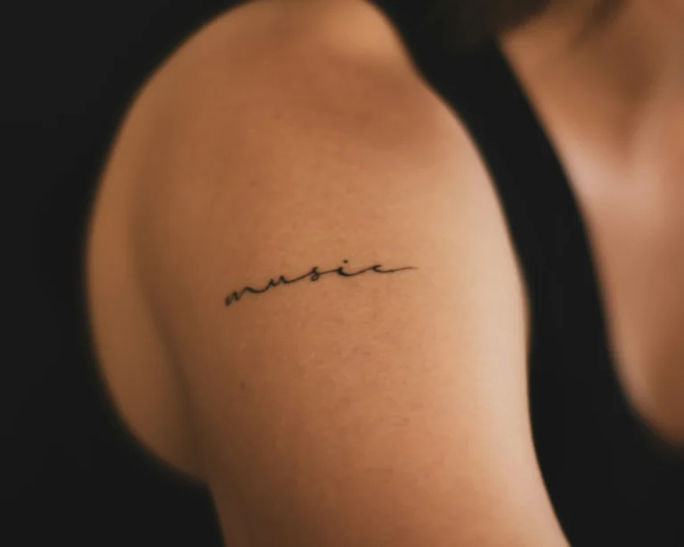 Fine-line script tattoo on a shoulder